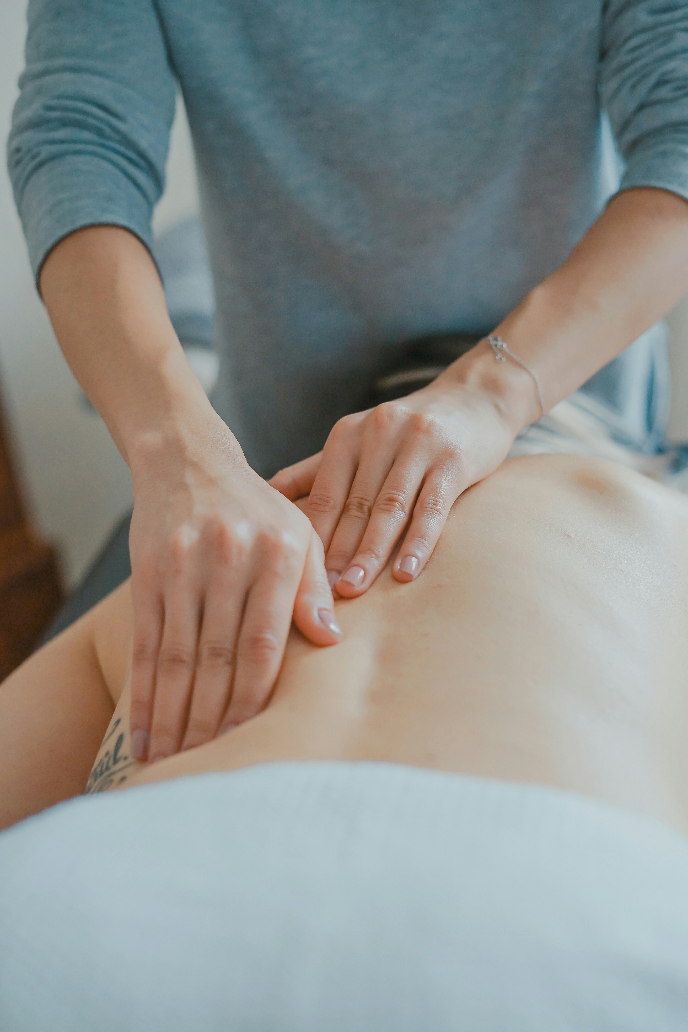 Calm in-home massage room with a treatment table, natural light, and warm neutral styling